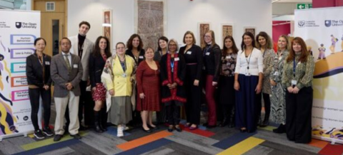 Group photo of Centre for Protecting Women Online team members and collaborators at The Open University event, standing in front of branded banners.