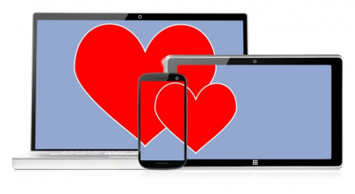 Red heart graphic displayed across smartphone, tablet, and laptop screens symbolising online connectivity and digital relationships.